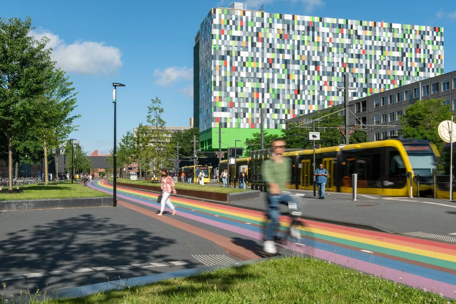 The Casa Confetti student housing tower at Utrecht Science Park, with a tram and a rainbow-painted cycle path in the foreground