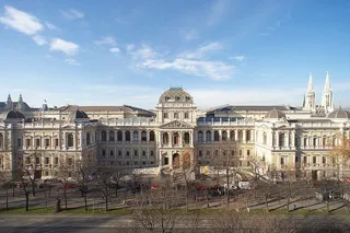 The main building of the University of Vienna seen from across the Ringstrasse, with the twin spires of the Votivkirche in the background