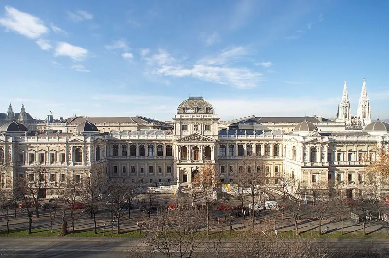 The main building of the University of Vienna seen from across the Ringstrasse, with the twin spires of the Votivkirche in the background
